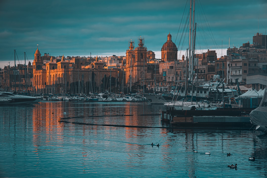Golden evening light on Valletta's honey-stone fortifications and the Grand Harbour with a ship at anchor